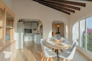 a dining room with a wooden table and white chairs at El Castillo in Calpe
