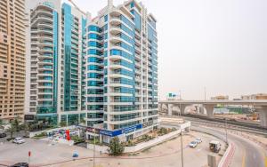 a large apartment building with blue windows and a freeway at Deluxe 2BR Apartment Dubai Marina View in Dubai