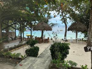 una playa con sillas y sombrillas y el océano en Pearl Resort Panglao,Dauis Bikini Beach, en Dauis