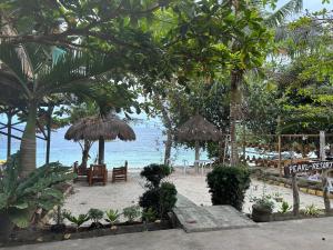 una playa con sillas y sombrillas y el océano en Pearl Resort Panglao,Dauis Bikini Beach, en Dauis