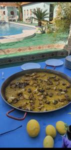 een pan eten op een tafel naast een zwembad bij Finca amor y sueño isa in Rafal