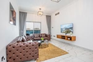a living room with a couch and a tv at Deluxe 2BR Apartment Dubai Marina View in Dubai
