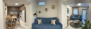 a living room with a blue couch and a kitchen at Marble House in Kavála