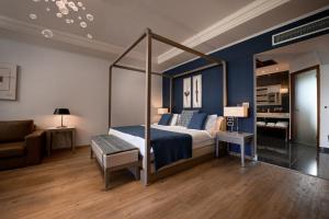 ein Schlafzimmer mit einem Himmelbett und einem Sofa in der Unterkunft Restia Suites Exclusive Resort -Adults Only in Almiros Beach