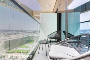 2 sillas y una mesa en una habitación con ventanas en Brandnew Building - Aykon Tower, Business Bay en Dubái