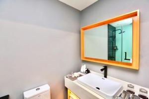 a bathroom with a sink and a mirror at Chengdu PODI Hotel in Chengdu