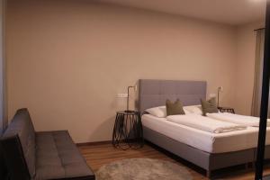 a bedroom with a large bed and a couch at Trautes Quartier in Bad Gleichenberg