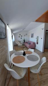 un soggiorno con tavolo e sedie bianchi di Rooms and Apartment Matosevic a Rovigno (Rovinj)