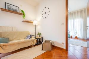 - un salon avec un canapé et un réveil sur le mur dans l'établissement Nadia Flat - Terme - Parking - WiFi, à Monte Ortone