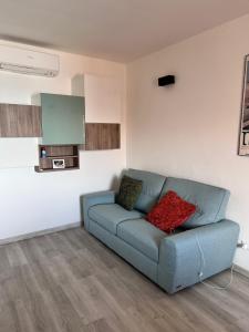 a living room with a blue couch with two red pillows at Le finestre sul mare in Rio Marina +9 photos