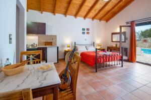 a kitchen and a bedroom with a bed and a table at Dive into Summer - Kirki's Cozy Pool Gem on Paxoi in Ieromónachos