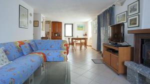 sala de estar con sofá azul y TV en Italianway - Panoramic Dream House en San Fedele Intelvi