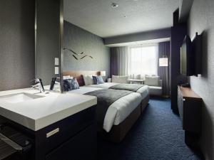 um quarto de hotel com uma cama e um lavatório em Mitsui Garden Hotel Gotanda - Tokyo em Tóquio