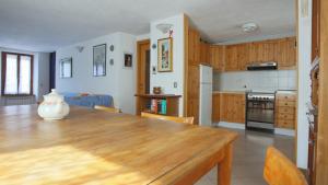 una gran cocina con una mesa de madera en una habitación en Italianway - Panoramic Dream House en San Fedele Intelvi