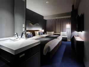 sypialnia z łóżkiem z umywalką i lustrem w obiekcie Mitsui Garden Hotel Gotanda - Tokyo w Tokio