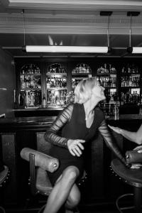 a woman sitting in a chair at a bar at Maison Delano Paris in Paris