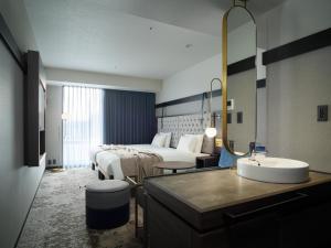 Pokój hotelowy z łóżkiem i umywalką w obiekcie Mitsui Garden Hotel Sapporo West w mieście Sapporo