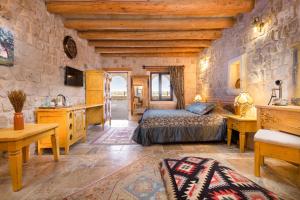a bedroom with a bed and a sink in a room at Cappadocia Acer Cave Hotel in Ortahisar