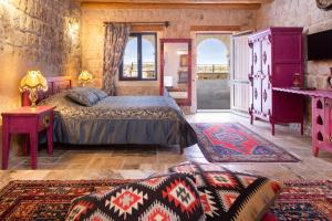 a bedroom with a bed and a large window at Cappadocia Acer Cave Hotel in Ortahisar