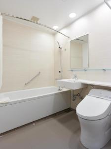 een witte badkamer met een toilet en een wastafel bij Mitsui Garden Hotel Otemachi - Tokyo in Tokyo