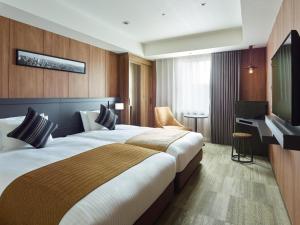 a hotel room with two beds and a television at Mitsui Garden Hotel Otemachi - Tokyo in Tokyo