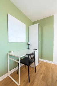 einen Schreibtisch mit Stuhl in einem Zimmer mit grünen Wänden in der Unterkunft Lille Hellemmes - Nice studio with parking ! in Lille