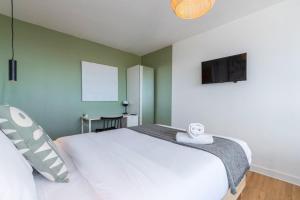 Schlafzimmer mit einem weißen Bett und einem Flachbild-TV in der Unterkunft Lille Hellemmes - Nice studio with parking ! in Lille