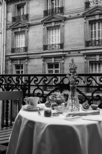 einen Tisch mit einem weißen Tischtuch und einer Blumenvase in der Unterkunft Maison Delano Paris in Paris