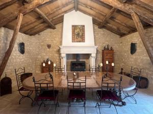 comedor con mesa, sillas y chimenea en Le Relais des Chevaliers "Suite des Seigneurs", en Cordes-sur-Ciel
