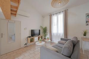 Una sala de estar con un sofá y un televisor. en La TOUR DES TEINTURIERS - AC CLIM - WiFi - BALCON, en Aviñón 19 fotos más