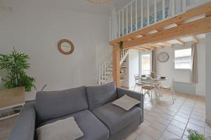 una sala de estar con un sofá y una mesa en La TOUR DES TEINTURIERS - AC CLIM - WiFi - BALCON, en Aviñón