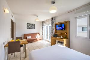 une chambre d'hôtel avec un lit et une salle à manger dans l'établissement Zenitude Hôtel-Résidences Le Maestria, à Antibes