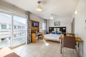 a bedroom with a bed and a large window at Zenitude Hôtel-Résidences Le Maestria in Antibes