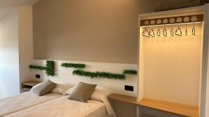 1 dormitorio con 1 cama y plantas en la pared en Hotel Playa de Sardiñeiro, en Finisterre