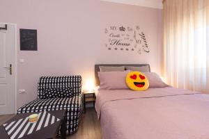 a bedroom with a bed with a chair and a pillow at Apartment Fiume in Rijeka