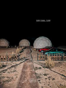 瓦迪拉姆的住宿－RUM YANAL CAMP，两辆汽车在晚上停在田野里