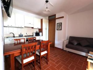 a kitchen and a living room with a table and chairs at Villetta a 100mt dal mare in Santa Caterina di Nardò