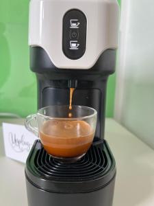 una macchinetta del caffè sta facendo una tazza di caffè di Unplug b&b a Quartu SantʼElena