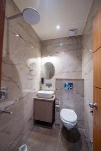 a bathroom with a white toilet and a sink at DEV RESIDENCY ( A UNIT OF THE ELEGANCE ) in Varanasi