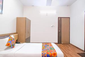 sypialnia z białym łóżkiem i kolorowym kocem w obiekcie FabHotel SS Residency w mieście kolkata
