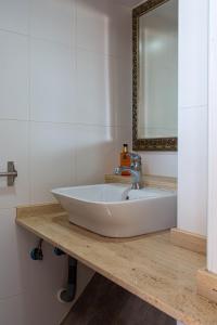 a bathroom with a white sink and a mirror at Arsenal 31 by Seaward Suites in Villajoyosa +5 photos