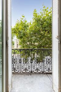 una puerta abierta a un balcón con un árbol en Studio Cosy avec vue sur le Chateau de Vincennes 1 en Vincennes