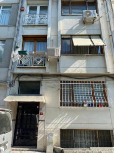 un grand bâtiment avec une porte et un balcon dans l'établissement Bakırköy Selvi Apartmanı, à Istanbul