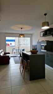 a kitchen and living room with a table and chairs at Archipel Capri in Valras-Plage