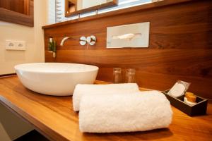 a bathroom with a white bowl sink on a wooden counter at Rebers Pflug in Schwäbisch Hall