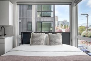 1 dormitorio con 1 cama y ventana grande en Blueground Capitol Hill patio walkable area SEA-722 en Seattle