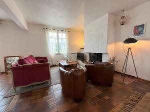uma sala de estar com mobiliário de couro e uma lareira em Maison le Vent du Large em Sibiril