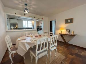 ein Esszimmer mit einem Tisch und weißen Stühlen in der Unterkunft Maison le Vent du Large in Sibiril