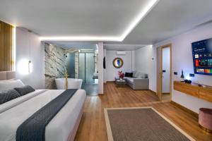 a bedroom with a large bed and a bath tub at CITYLUXE Suites & Rooms in Athens