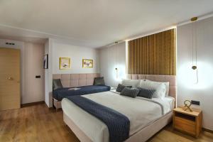 a bedroom with two beds with blue pillows at CITYLUXE Suites & Rooms in Athens